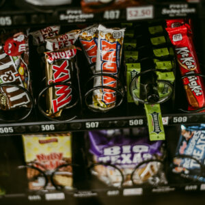 Distributeur automatique de snacks avec plusieurs rangées de barres chocolatées et bonbons emballés